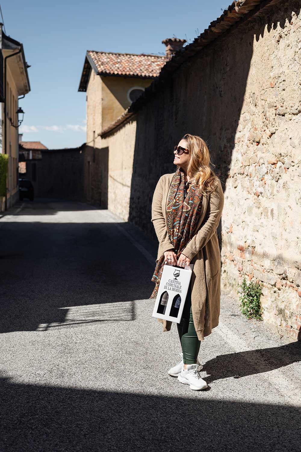 Degustando i vini in cantina e visitando i castelli che dominano le colline.